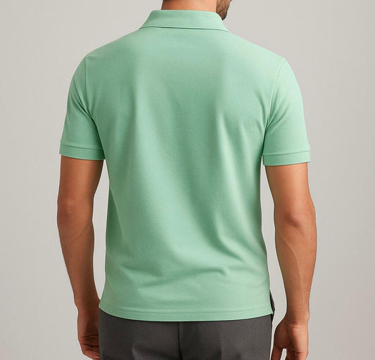 Person wearing a light green polo shirt on a plain background